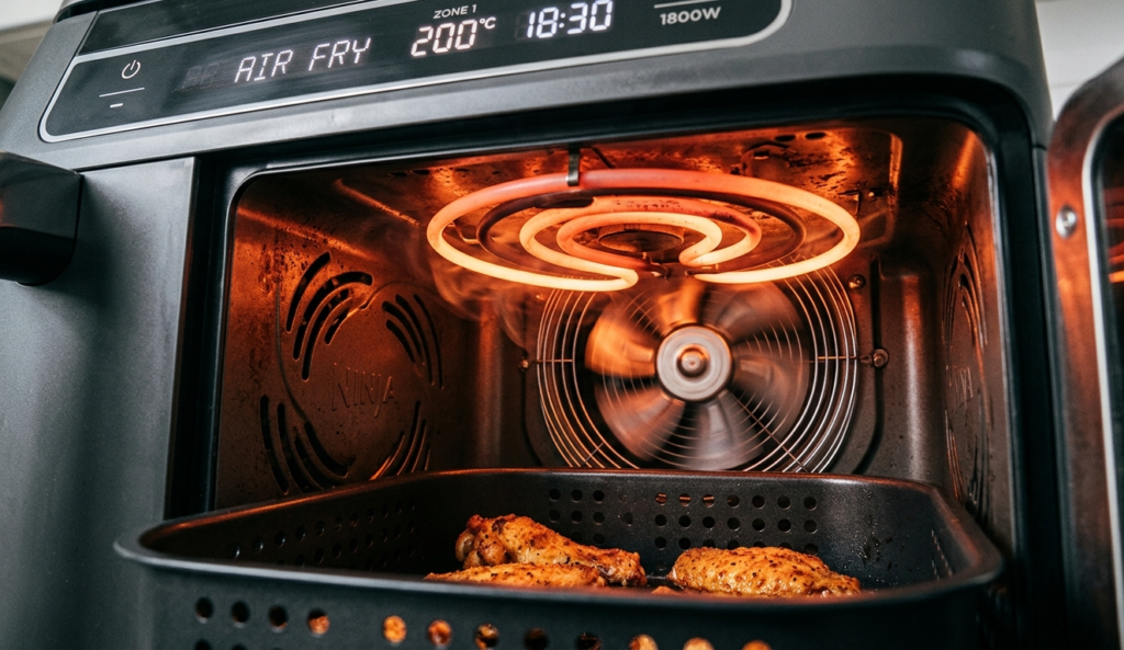 Air fryer interior with glowing 1800W heating element and spinning fan — showing how wattage powers air frying. Air Fryer wattage