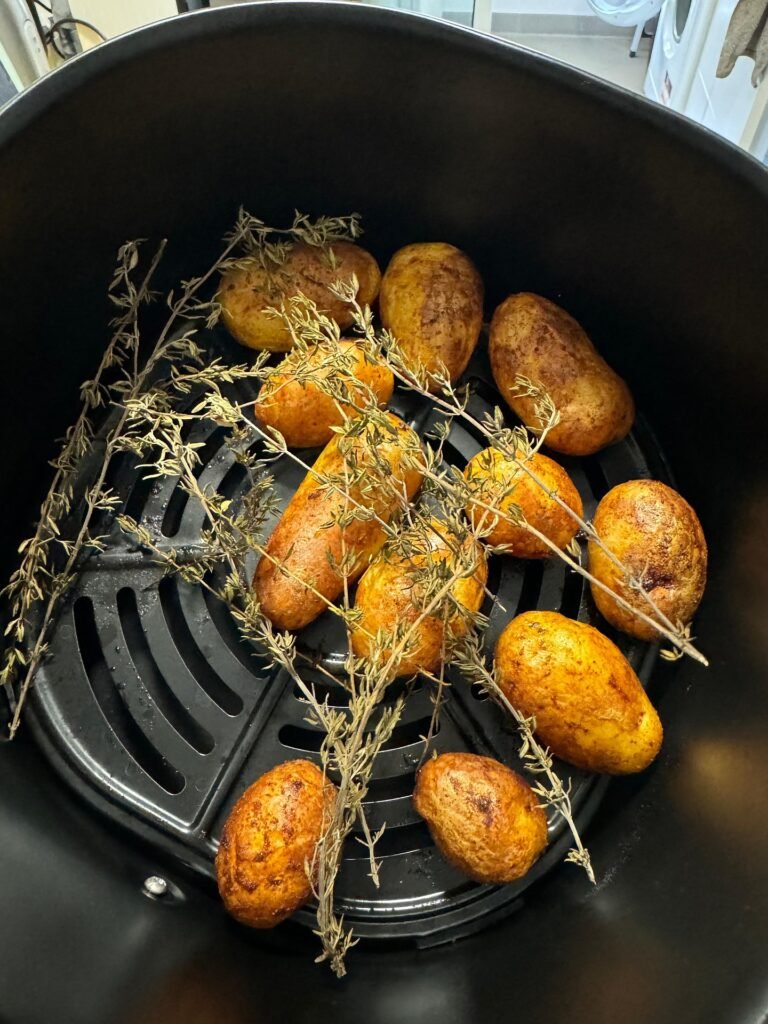 Potatoes roasting in an air fryer basket — part of the air fryer buying guide on FoodUnitesPeople
